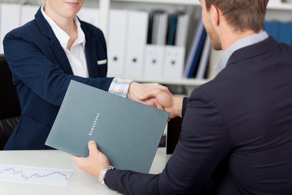 midsection,of,a,businessman,shaking,hands,with,a,female,interviewer